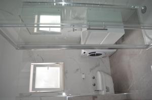 uma casa de banho com um lavatório, um espelho e uma janela em Apartments Vinka em Podstrana