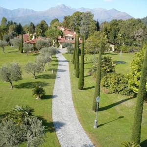 a gravel path in a park with trees and houses at LAVANDA appartamento in Vigliano Biellese