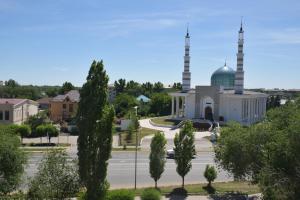 a mosque in a city with a street and trees at Мода в доме 13 in Oral