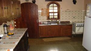 a kitchen with wooden cabinets and a sink and a refrigerator at Casa das dálias in Monte Verde