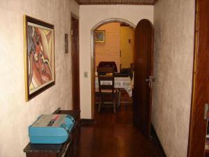 a hallway of a house with a room with a table at Casa das dálias in Monte Verde +14 photos