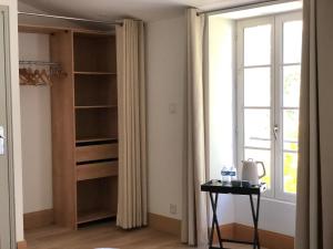 Habitación con armario, ventana y mesa. en Les voiles rouges en Saint-Martin-de-Ré