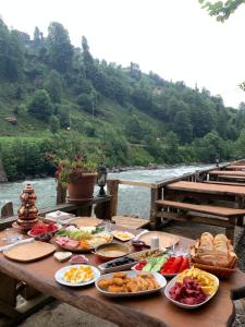 a table with food on it next to a river at Tanura Bungalows in Çamlıhemşin