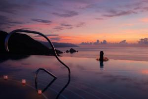 a woman sitting in the water in the ocean at Hotel Mousai - Adults Only in Puerto Vallarta