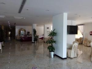 a lobby with a large room with tables and chairs at شهد الأولى للشقق المخدومة in Taif