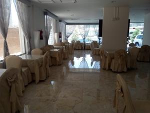 a room with tables and chairs in a room with windows at شهد الأولى للشقق المخدومة in Taif