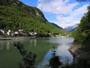 a river in a valley with houses and mountains at Appartamento CADELAVE in Villa di Chiavenna