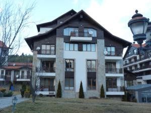 a large white building with a black roof at PM Services Semiramida Apartments in Borovets
