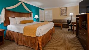 a hotel room with a large bed and a couch at Best Western Harbour Inn & Suites Huntington - Sunset Beach in Huntington Beach +37 photos
