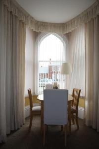 comedor con mesa, sillas y ventana en No2 Abbey View Apartment, en Whitby