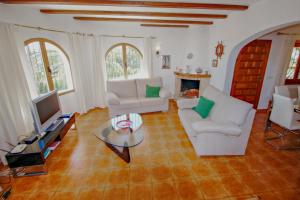 un salon avec deux canapés blancs et une télévision dans l'établissement San Jaime-19M - sea view villa with private pool in Moraira, à Pedramala
