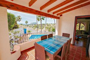 - une salle à manger avec une table et une vue sur la piscine dans l'établissement San Jaime-19M - sea view villa with private pool in Moraira, à Pedramala