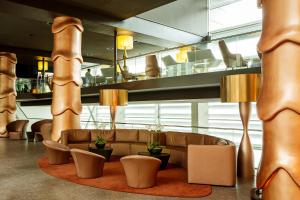 a lobby with a couch and tables and chairs at Room Mate Aitana in Amsterdam