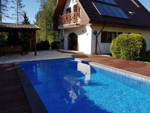 uma piscina em frente a uma casa em WIGWAM Dom z basenem na Kaszubach em Sulęczyno