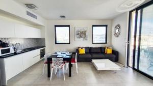 a kitchen and living room with a table and a couch at BnB Israel Apartments - Shalom Alehem Joie in Tel Aviv