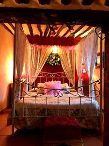 - une chambre avec un lit à baldaquin dans l'établissement La Quinta de Malu romantic hotel in Cuenca, à Valeria