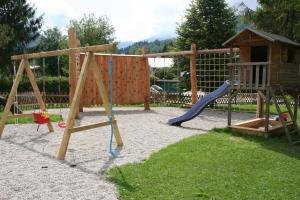a playground with a slide and a swing set at Outdoorhotel Jäger Von Fall in Lenggries