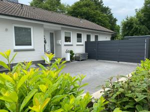 une maison avec une clôture noire et une allée dans l'établissement Family Ferienhaus Ennens, à Rhauderfehn