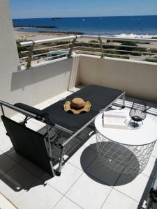 - un chapeau assis sur une table sur un balcon dans l'établissement Bleu du Sud, au Cap d'Agde