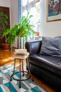 a living room with a leather couch and a table at Aparthotel Hornigold "W Zielonej Kamienicy" in Katowice