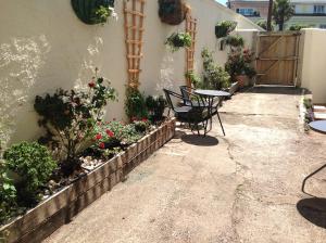 - une terrasse avec une table, des chaises et des fleurs dans l'établissement Seaways, à Paignton
