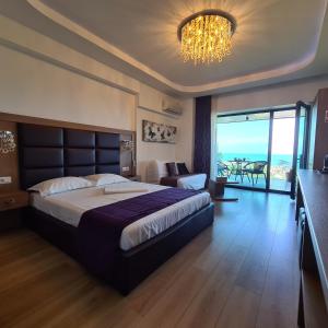 a bedroom with a large bed and a chandelier at Studio Tia in Mamaia