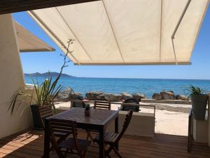 una mesa y sillas en una terraza con vistas al océano en A l 'orée de l ô 2, en La Ciotat