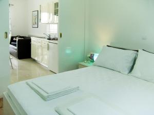 a white bed in a room with a kitchen at Apartments Villa Pina in Vodice