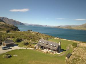 an aerial view of a house on a hill with a lake at Buchanan Lodge - 60 acres on Wanaka lakefront in Wanaka
