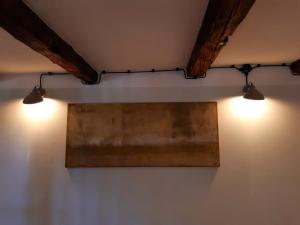 deux lumières sur un mur avec un tableau dessus dans l'établissement Wohlfühl Appartement - Kaisereinsde - traditionelles Lehmhaus Parken gratis, à Quedlinbourg