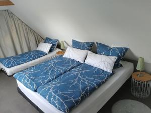 ein Bett mit blau-weißen Laken und Kissen in der Unterkunft Backstage Apartment Kiel-Holtenau in Kiel