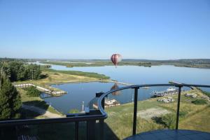 a hot air balloon flying over a river at Panorama Apartman in Velence