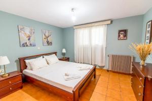 a bedroom with a large bed and a window at Pine trees apartment in Preveza