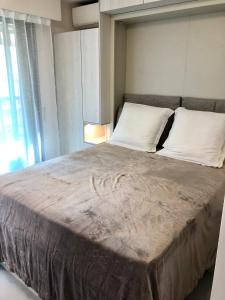ein Schlafzimmer mit einem großen Bett und weißen Kissen in der Unterkunft Studios Nice Gambetta in Nizza