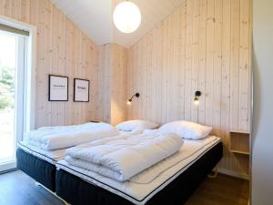 twee bedden in een kamer met houten wanden bij Holiday home Fanø CXXXIV in Fanø