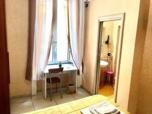1 dormitorio con escritorio, ventana y lavamanos en B&B Quattro Palazzi Napoli Centro, en Nápoles