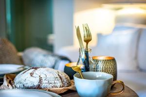 a table with a cup of coffee and a plate of bread at Onder de Linde B&B in Valkenburg