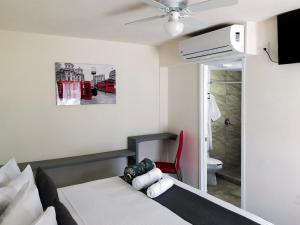 休特佩克的住宿－AOHOM SANTUARIO HOTEL & SPA，一间卧室配有一张床和一张红色椅子