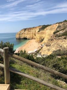 a view of a beach from a wooden fence at Apartamento em cima da praia - Carvoeiro - Algarve in Poço Partido