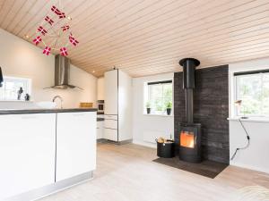 a kitchen with a fireplace in the middle of a room at Holiday home Hvide Sande XCIII in Bjerregård