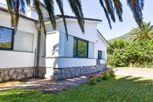 een wit huis met een palmboom bij ¡Nuevo! Espectacular casa en la playa de Berria in Santoña