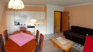 cocina y sala de estar con mesa y sofá en Seehaus Karantanien am Ossiacher See, en Ossiach