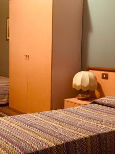 a bedroom with a bed and a cabinet with a bedspread at Albergo Fonda in Villarotta +14 photos
