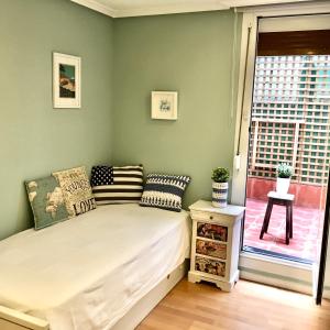 a small bed in a room with a window at Apartamento estilo Vintage muy céntrico y parking gratis in Logroño
