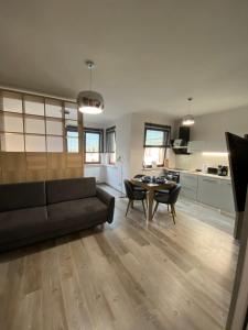a living room with a black couch and a table at Apartament Drewno i Morze in Gdańsk