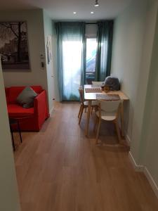 een woonkamer met een tafel en een rode bank bij Precioso apartamento 3hab en Valencia (Benimaclet) in Valencia