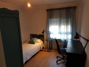 een slaapkamer met een bed, een bureau en een raam bij Precioso apartamento 3hab en Valencia (Benimaclet) in Valencia