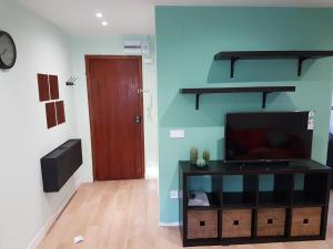 een woonkamer met een flatscreen-tv en een deur bij Precioso apartamento 3hab en Valencia (Benimaclet) in Valencia