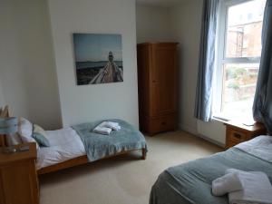 een slaapkamer met 2 bedden en een foto van een vuurtoren bij Freshford House in Weymouth