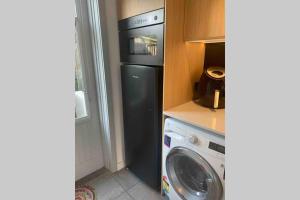 a kitchen with a refrigerator and a washing machine at Sorrento Back Beach Apartment at Oceanic Apt 7 in Sorrento